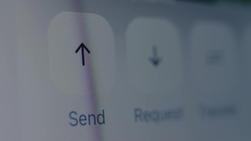 A close-up macro shot of a finger tapping the 'Send' button on a digital screen for a mobile banking transaction