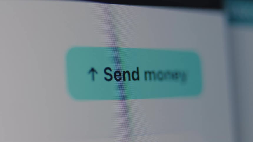 A macro close-up of a 'Send money' button on a digital screen, representing online banking and digital transactions
