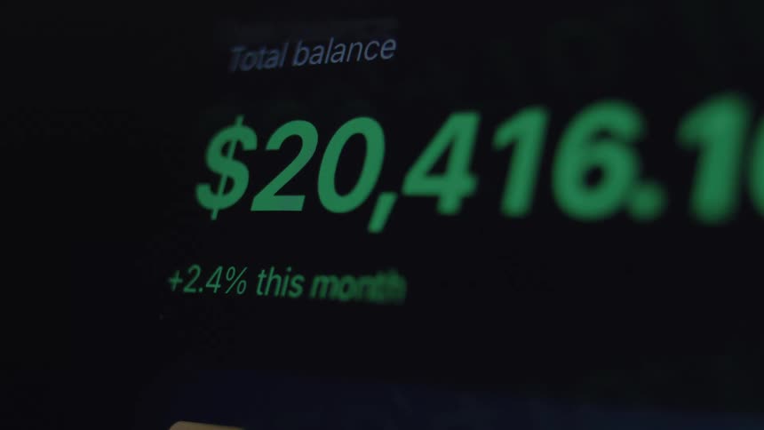 A close-up of a digital financial account showing the total balance rapidly increasing, indicating profit and wealth growth
