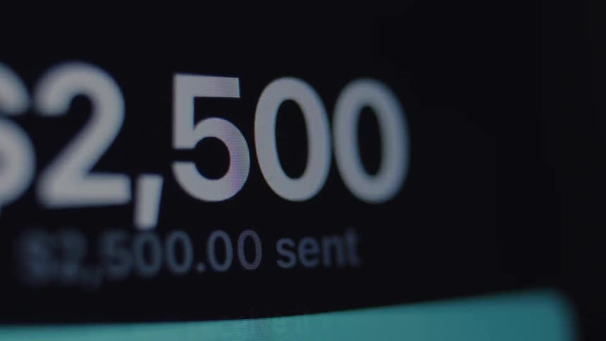 A close-up macro view of a digital screen as a user types in a dollar amount and successfully sends an online money transfer