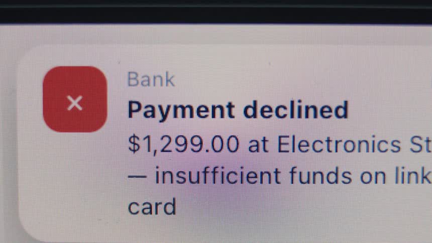 A close-up of a digital screen showing a bank notification that a payment has been declined due to insufficient funds