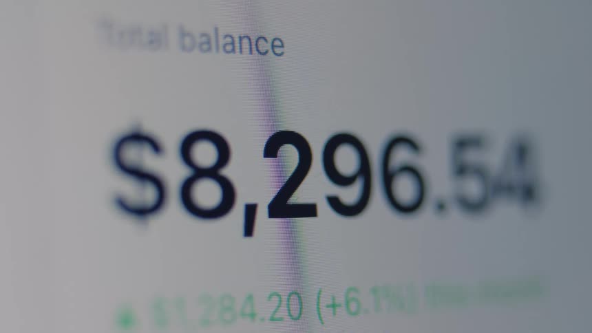 Close-up of a financial account's total balance decreasing on a digital screen