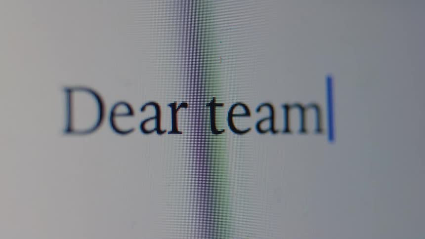 A macro close-up shot of the words 'Dear team,' being typed on a computer screen, revealing the individual pixels