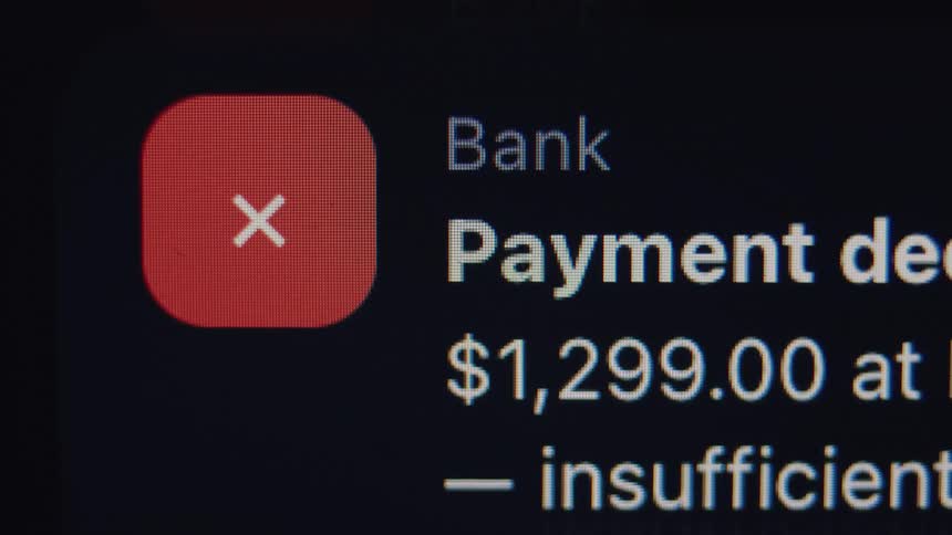 A close-up macro shot of a 'Payment Declined' bank notification on a screen due to insufficient funds