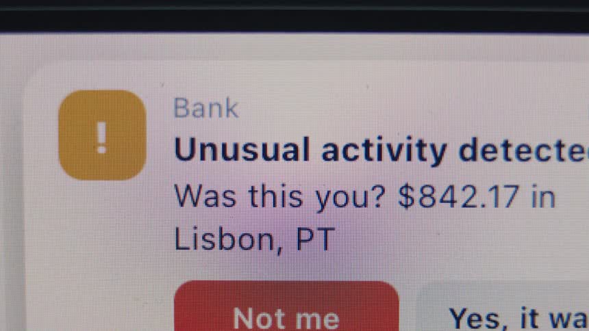 A close-up of a bank's fraud alert notification on a digital screen asking to confirm an unusual transaction
