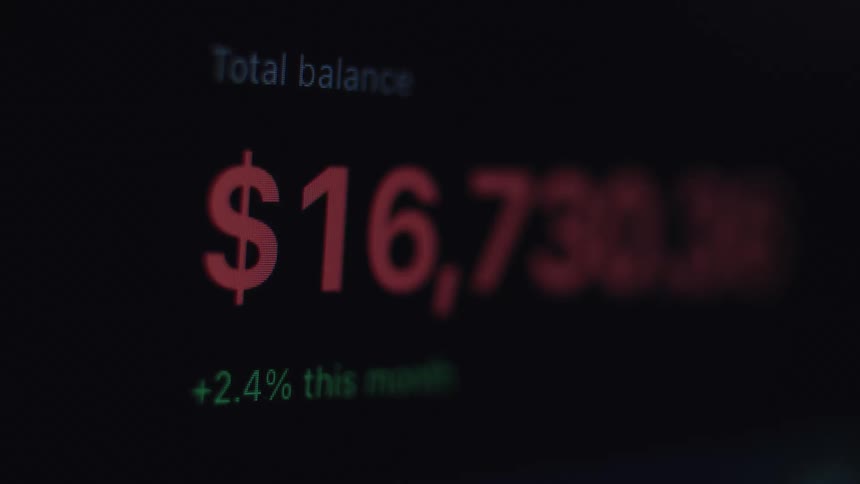A close-up of a digital screen showing a financial account balance flashing red as a warning or alert