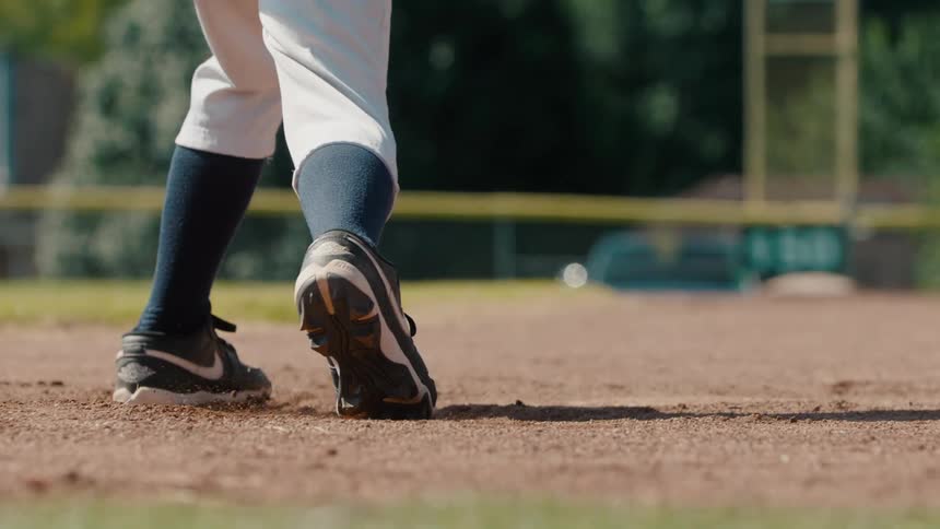 Slow motion low-angle shot of a baseball player's cleats digging into the dirt of the pitcher's mound