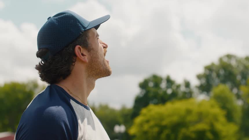 A slow-motion close-up of a baseball player with a mustache throwing a ball and celebrating victoriously
