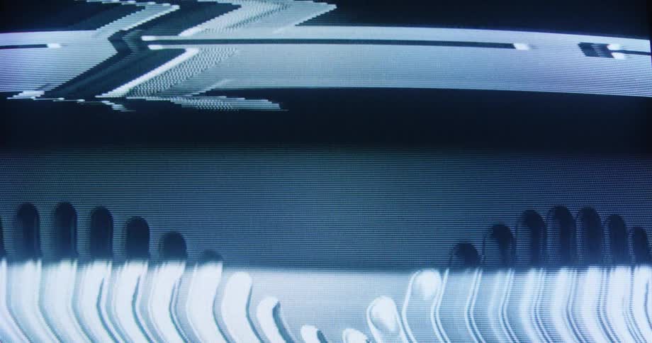 Analog video glitches and TV noise flicker across a dark screen in a close-up shot