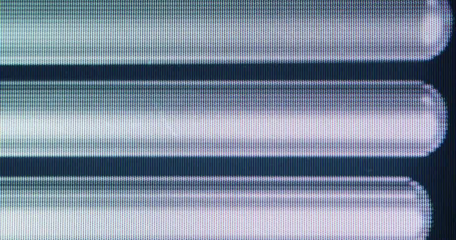 Pixelated digital loading bars animate in a seamless loop in this macro shot of a computer screen