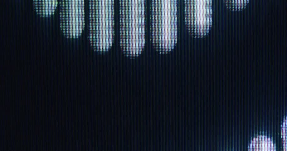 A macro close-up of a digital screen displays abstract glowing light bars moving in a seamless, wave-like animation