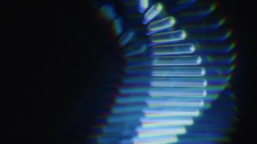 An abstract, glowing, and futuristic DNA helix rotates slowly with a blurred, holographic effect against a dark background