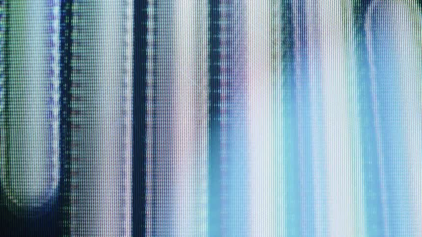 A close-up macro view of an LCD screen displays abstract, glowing, pixelated shapes and vertical lines with colorful light leaks
