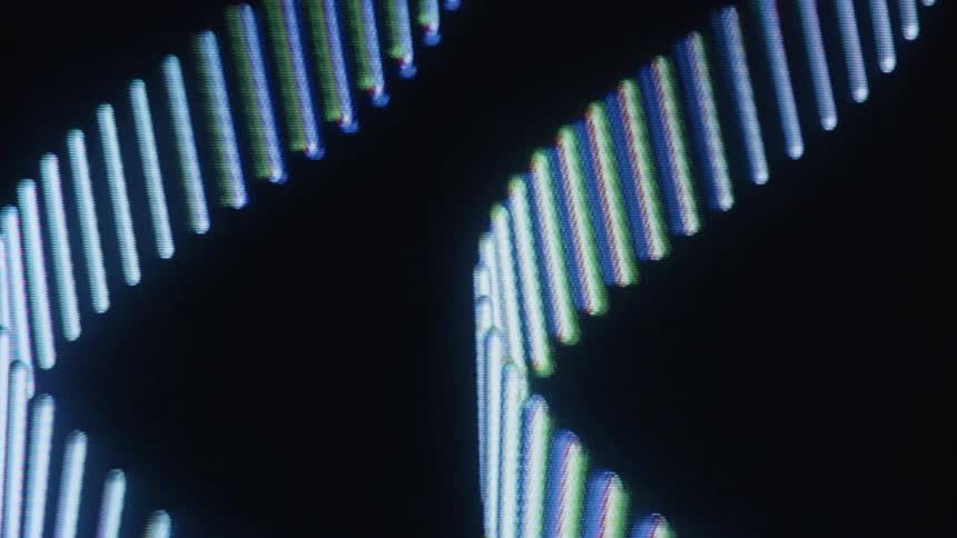 A macro view of an abstract helix of colorful, glowing lines slowly moving across a dark screen