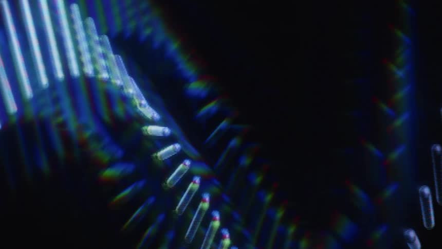 A mesmerizing loop of abstract blue digital lines undulates in a wavy pattern, refracting light with a prismatic effect against a black background