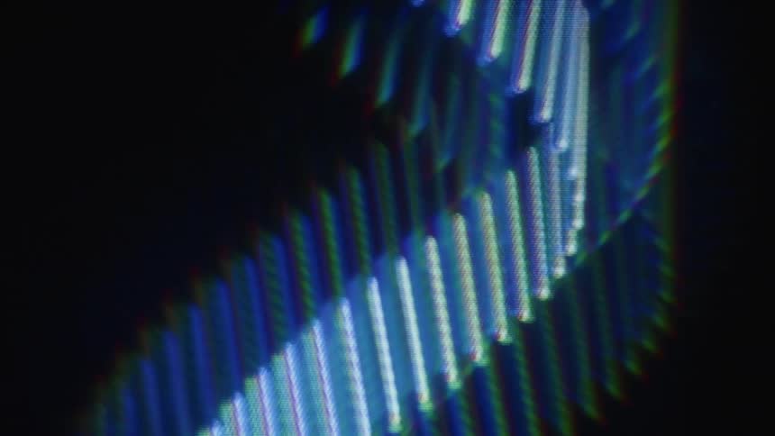 Dreamy abstract view of glowing blue diagonal lines with a colorful prismatic light effect on a dark background