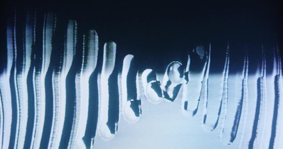 Close-up of a television screen showing analog video feedback with distorted black and white lines