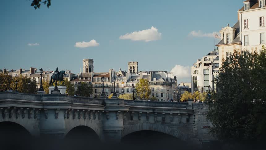 A picturesque view of the historic Pont Neuf bridge over the Seine River on a sunny day in Paris, France