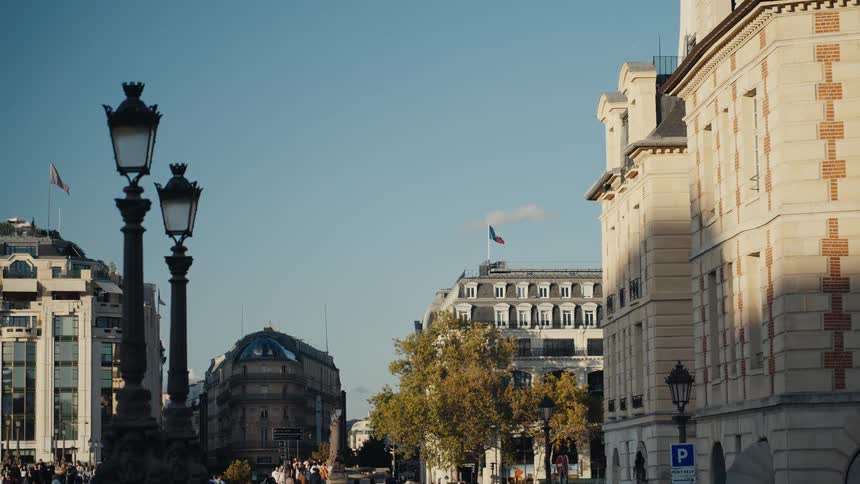 A classic Parisian street view with ornate street lamps and a French flag waving on a sunny day