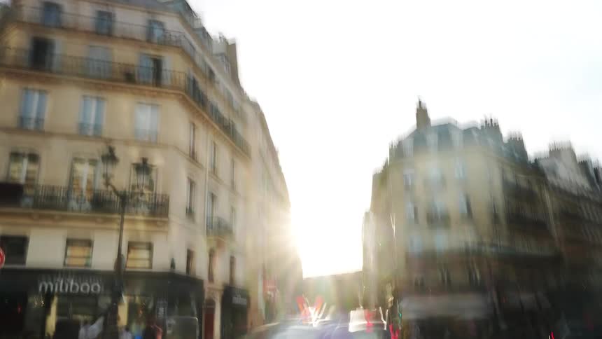 Chaotic motion blur hyperlapse transforms into a clear time-lapse of a busy Parisian street corner during a beautiful sunset