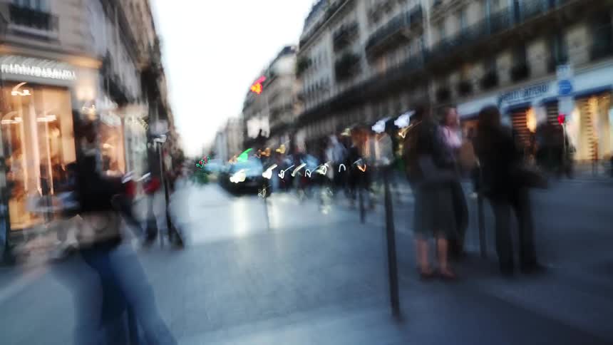 A dizzying first-person perspective walk through a bustling Parisian street at dusk, captured with a long exposure effect that creates abstract light trails and motion blur