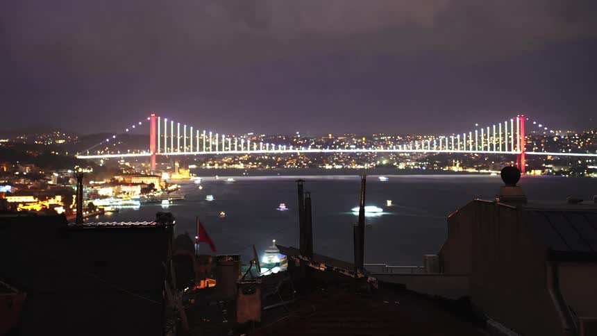 A stunning night time-lapse shows boats cruising on the Bosphorus under the illuminated bridge in Istanbul, Turkey