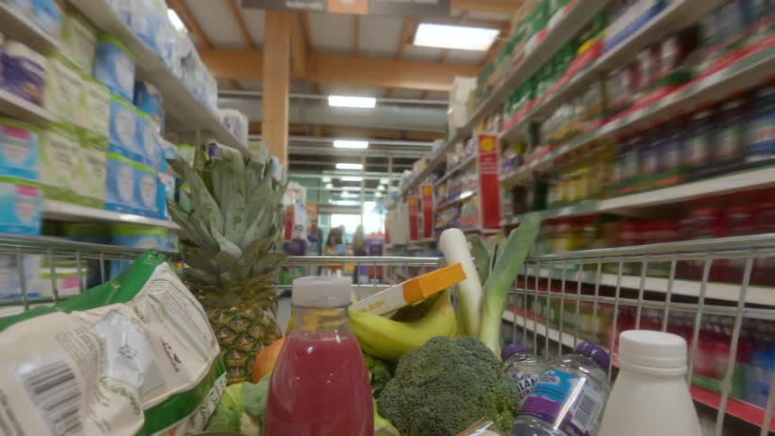 A fast-paced timelapse from the perspective of a shopping cart filled with groceries speeding through a supermarket
