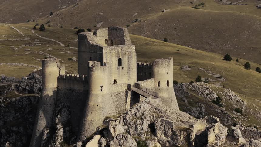 A timelapse shows shadows moving across the ancient Rocca Calascio castle ruins perched on a rocky mountain in Italy