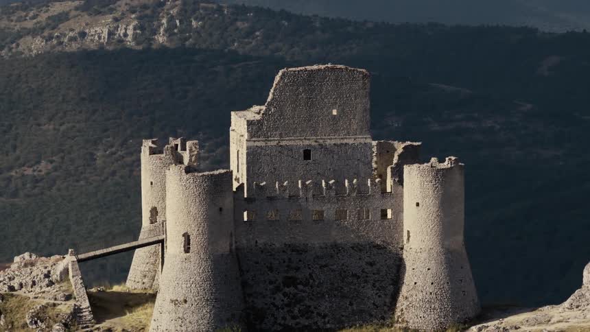 A time-lapse of the ancient, ruined castle of Rocca Calascio in Italy as shadows move across its stone walls and the surrounding mountains