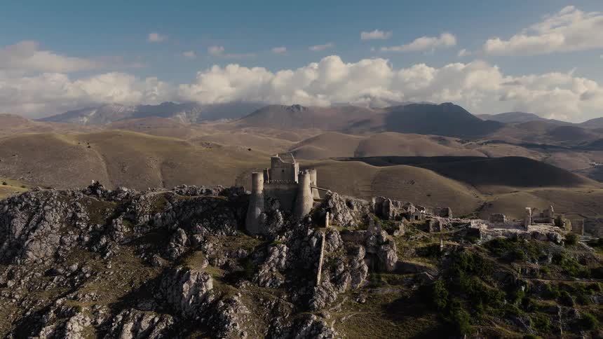 Epic time-lapse aerial shot of the ancient Rocca Calascio castle ruins on a rocky peak in the Italian mountains of Abruzzo