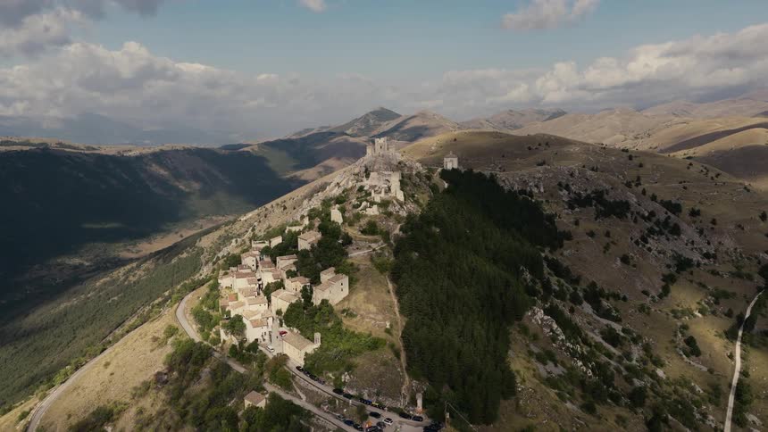 An epic aerial flight approaches the stunning medieval Rocca Calascio castle ruins high on a mountaintop in Abruzzo, Italy