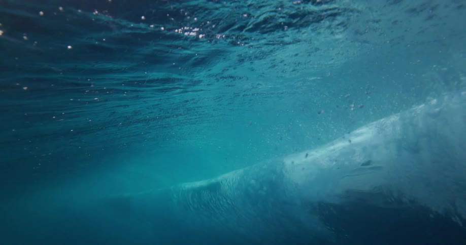 The majestic curl of an ocean wave is seen from below the surface in stunning slow motion