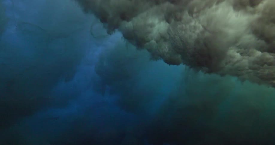 The powerful turbulence of an ocean wave breaking is seen from below the surface in slow motion