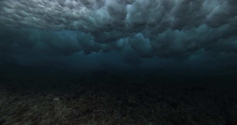 Dramatic slow motion underwater view of a powerful ocean wave breaking overhead