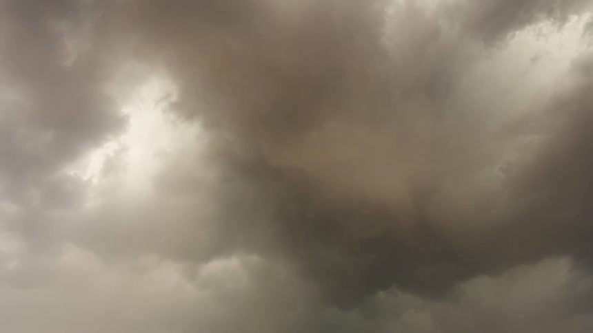 A dramatic static shot captures the slow, churning movement of dark, ominous storm clouds in the sky