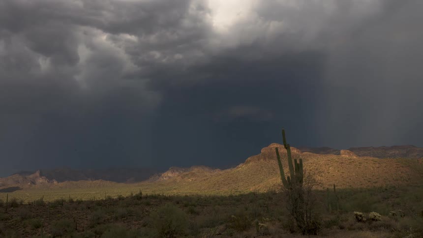 A powerful monsoon storm with dark, dramatic clouds rolls over the Sonoran Desert in a beautiful timelapse