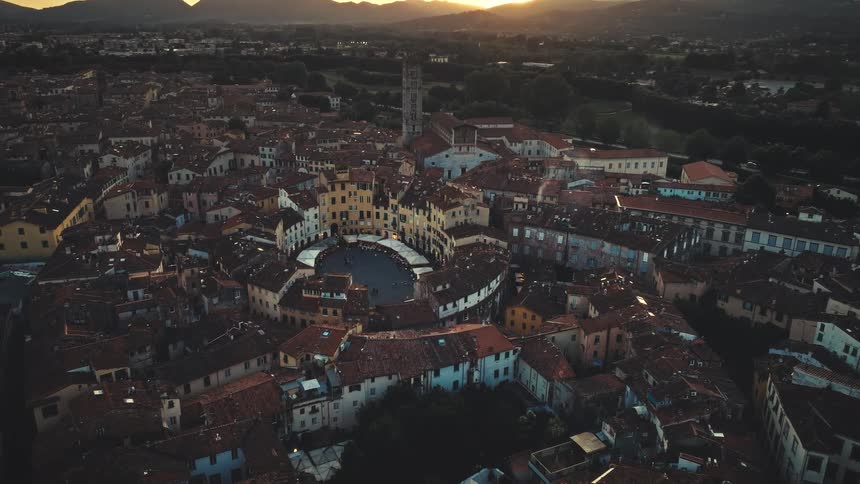 Time-lapse aerial of the sun setting over the Piazza dell'Anfiteatro in the historic city of Lucca, Tuscany