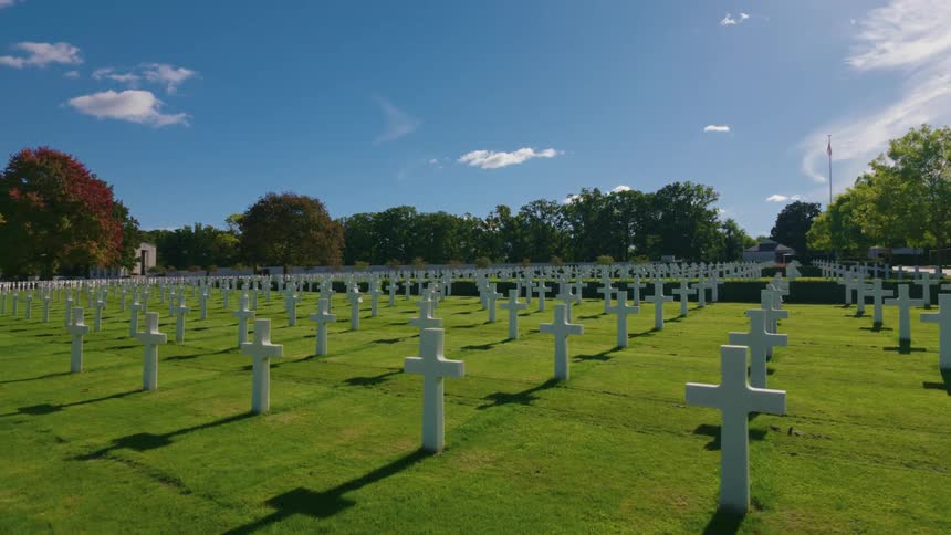 Timelapse of shadows moving across the endless rows of white crosses at the Normandy American Cemetery on a sunny day
