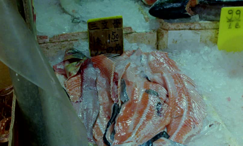 Raw salmon carcasses lie on a bed of crushed ice for sale at an Asian fish market