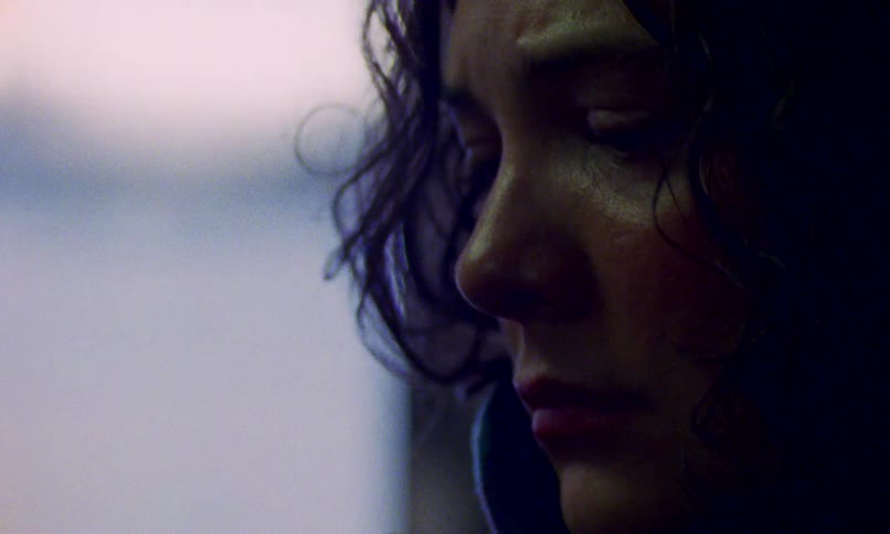 A mysterious futuristic black device is held by a woman whose face reveals a deep sense of worry
