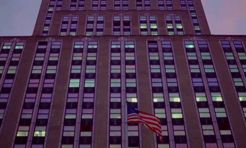 A dramatic low-angle tilt shot reveals the iconic Empire State Building from its entrance to the illuminated spire at dusk