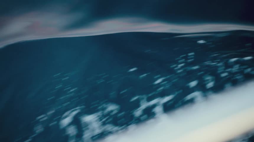 A dramatic, blurry, slow-motion close-up of dark blue ocean waves created by a moving boat