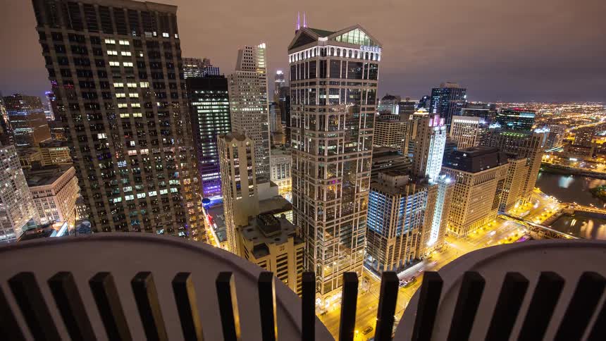 A stunning high-angle timelapse captures the vibrant Chicago cityscape at night, with traffic streaming below and clouds moving overhead