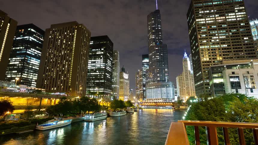 A stunning night timelapse of tour boats cruising down the Chicago River surrounded by the illuminated city skyline
