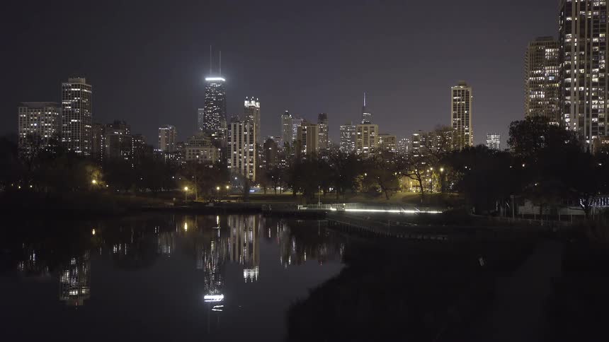 The brilliant Chicago skyline reflects perfectly in the calm waters of Lincoln Park at night