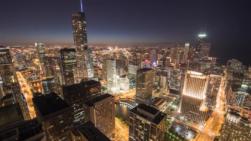 A stunning high-angle time-lapse of the Chicago skyline transitioning from a vibrant dusk to a brightly illuminated night