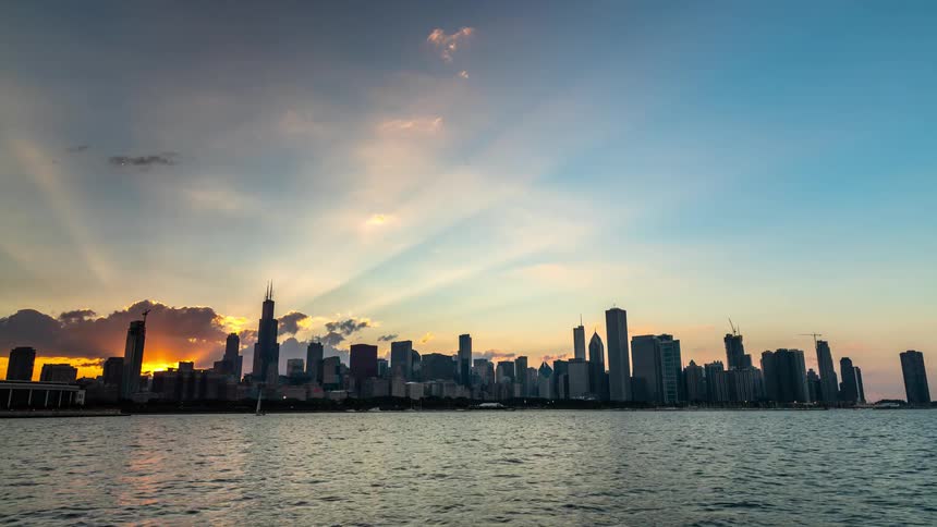 A stunning day-to-night timelapse of the Chicago skyline as viewed from Lake Michigan, capturing the sunset and the city lights coming alive