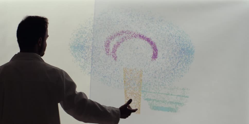 A scientist manipulates a colorful digital model of a human brain on a futuristic interactive screen