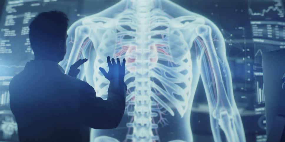 A medical professional interacts with a futuristic holographic display of the human cardiovascular and skeletal systems