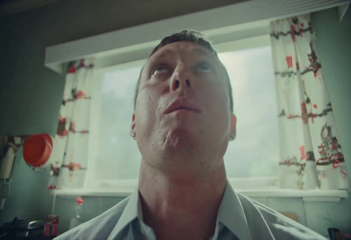 A man experiences a moment of pure bliss as he eats a piece of green candy in a stylized low-angle shot